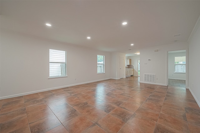 unfurnished room featuring light tile patterned flooring, a wealth of natural light, and crown molding