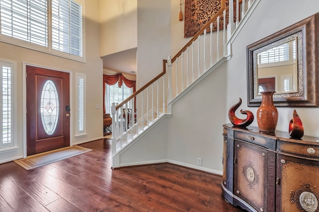 entryway featuring dark wood-type flooring and a high ceiling