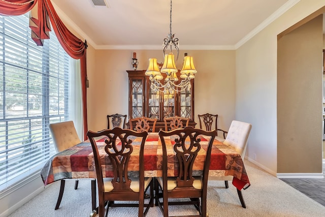 carpeted dining space with ornamental molding, a wealth of natural light, and a chandelier