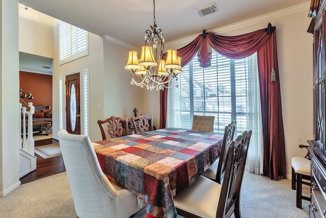 dining area with an inviting chandelier, light hardwood / wood-style floors, and crown molding