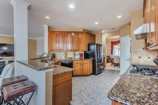 kitchen featuring black appliances, dark stone counters, decorative backsplash, sink, and kitchen peninsula