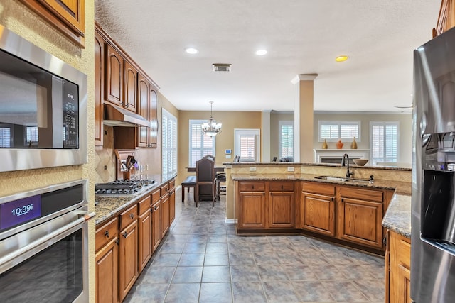 kitchen featuring light stone countertops, a wealth of natural light, sink, and stainless steel appliances