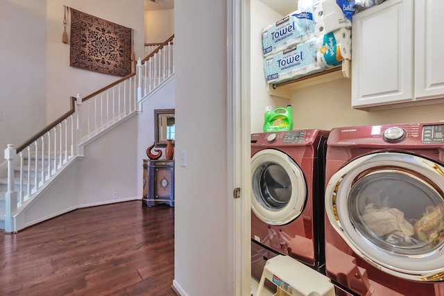 washroom with dark wood-type flooring, washing machine and dryer, and cabinets