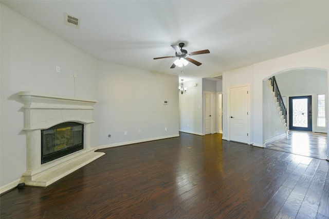 unfurnished living room featuring dark wood-type flooring and ceiling fan