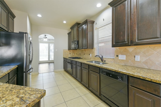 kitchen with tasteful backsplash, stainless steel appliances, dark brown cabinets, sink, and ceiling fan