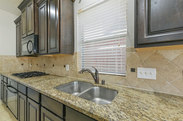 kitchen with dark brown cabinetry, appliances with stainless steel finishes, sink, and backsplash