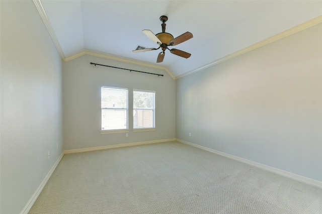 spare room featuring ceiling fan, light colored carpet, crown molding, and vaulted ceiling