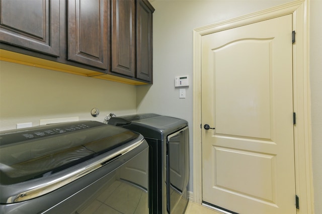 clothes washing area with cabinets, light tile patterned flooring, and separate washer and dryer