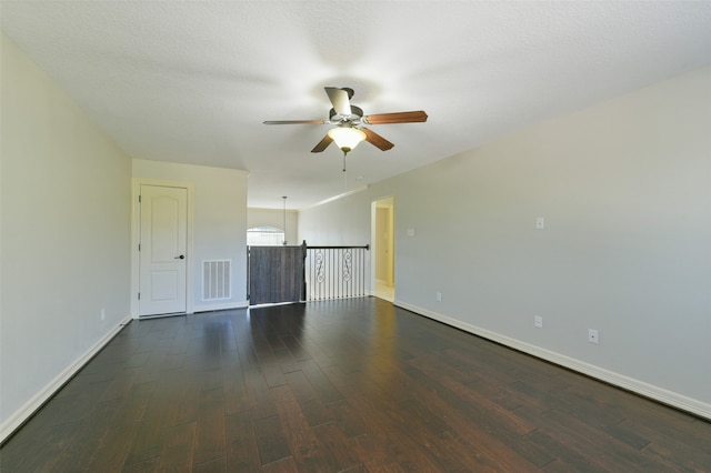 unfurnished room featuring a textured ceiling, dark wood-type flooring, and ceiling fan