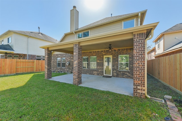 rear view of property featuring ceiling fan, a yard, and a patio