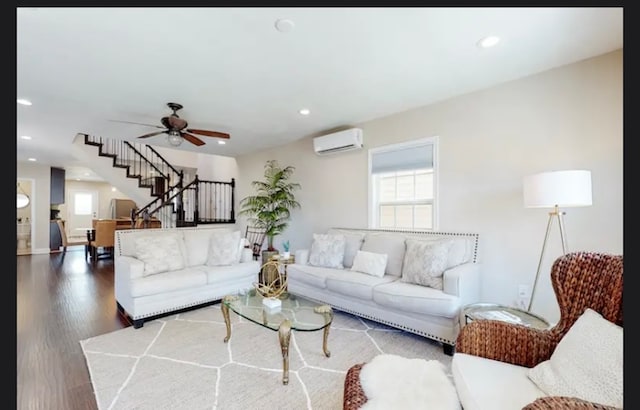 living room with hardwood / wood-style flooring, ceiling fan, and a wall mounted air conditioner