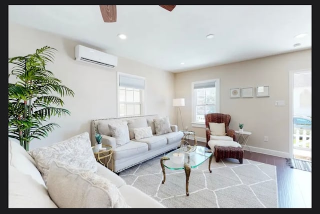 living room with ceiling fan, hardwood / wood-style flooring, and a wall mounted AC