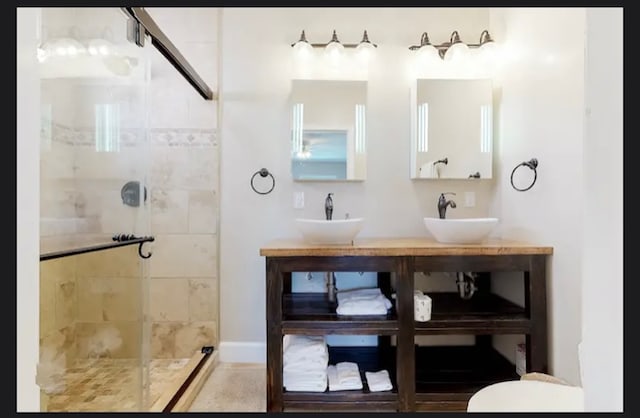 bathroom featuring vanity and tiled shower