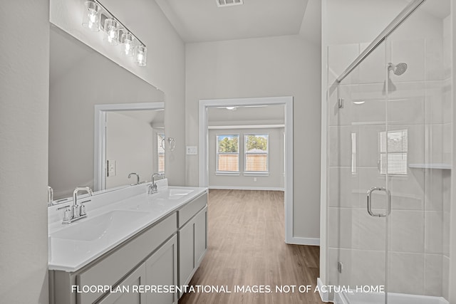 bathroom featuring an enclosed shower, lofted ceiling, hardwood / wood-style flooring, and vanity