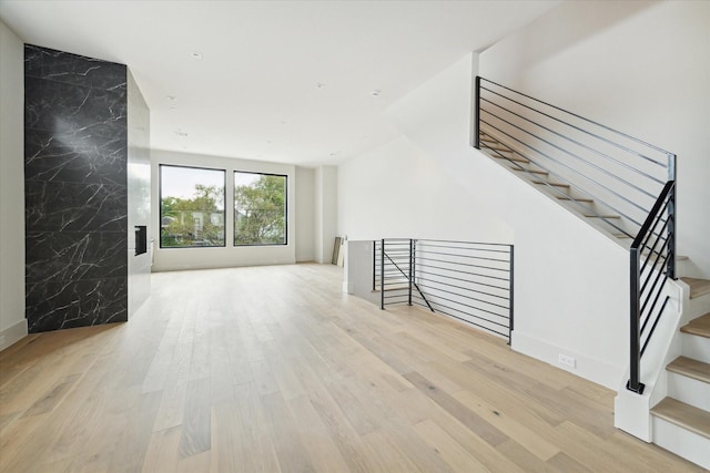 unfurnished living room with light hardwood / wood-style floors and tile walls