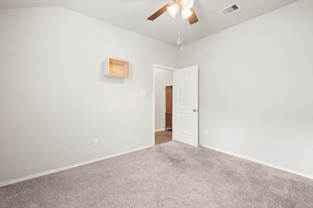 spare room featuring carpet, ceiling fan, and vaulted ceiling