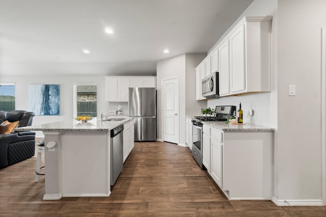 kitchen featuring stainless steel appliances, dark hardwood / wood-style flooring, a healthy amount of sunlight, and white cabinets