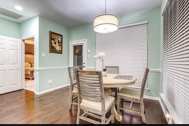 dining room featuring dark hardwood / wood-style floors and a textured ceiling