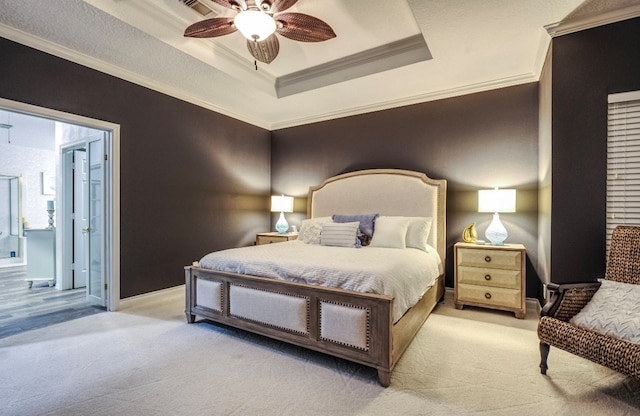 carpeted bedroom with ornamental molding, ceiling fan, a raised ceiling, and connected bathroom