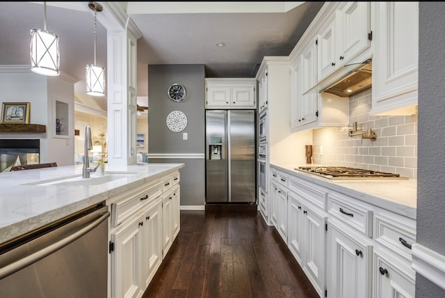 kitchen with stainless steel appliances, white cabinets, dark hardwood / wood-style floors, crown molding, and decorative light fixtures