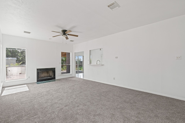 unfurnished living room featuring carpet flooring and a healthy amount of sunlight