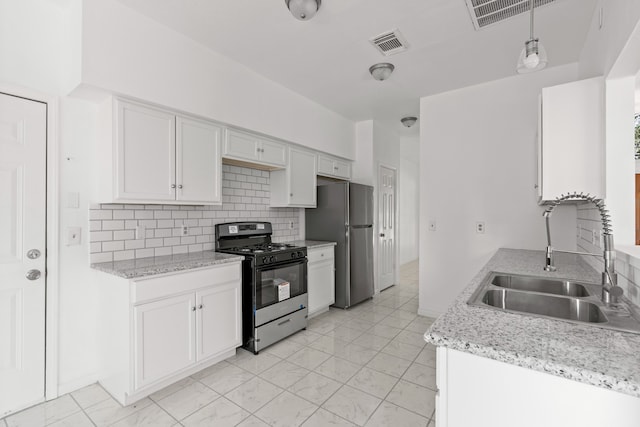 kitchen featuring stainless steel fridge, white cabinetry, sink, and gas stove