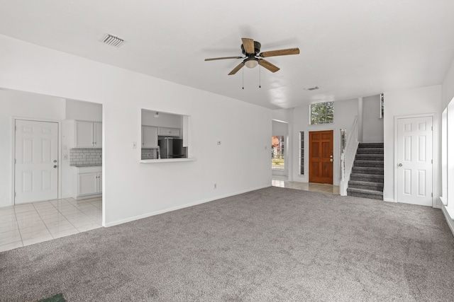 unfurnished living room with ceiling fan and light colored carpet