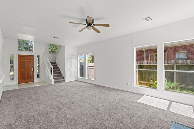 unfurnished living room featuring ceiling fan and light colored carpet