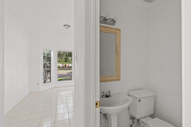 bathroom featuring toilet, sink, and tile patterned flooring