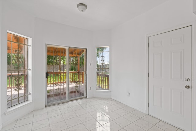 empty room featuring light tile patterned floors and a healthy amount of sunlight