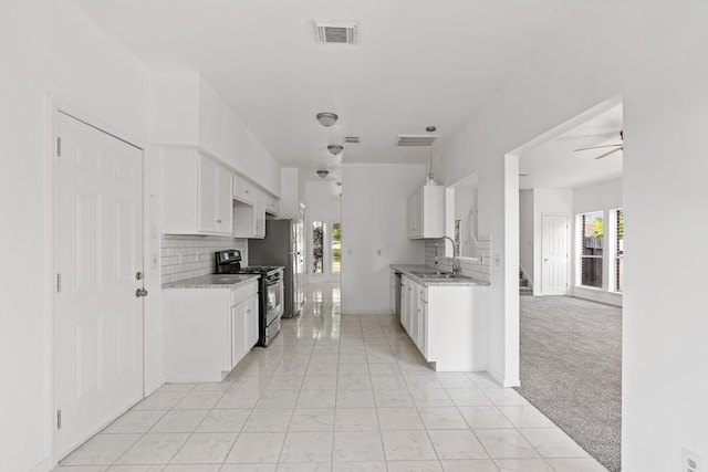 kitchen with white cabinetry, stainless steel range with gas cooktop, light carpet, and plenty of natural light