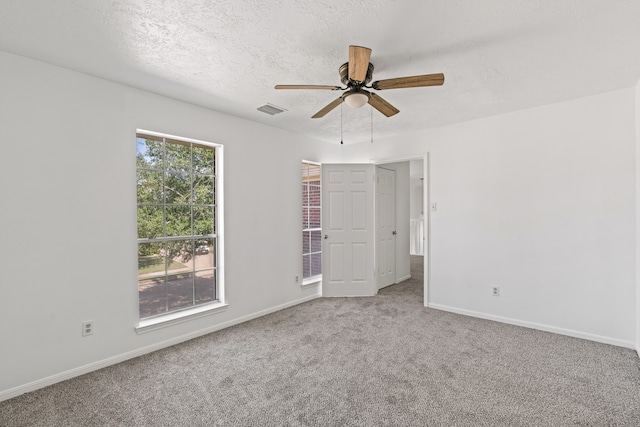 carpeted empty room with a textured ceiling and ceiling fan