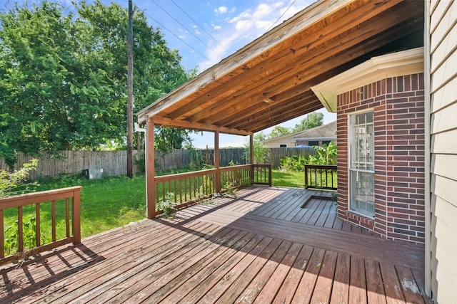 wooden terrace featuring a lawn