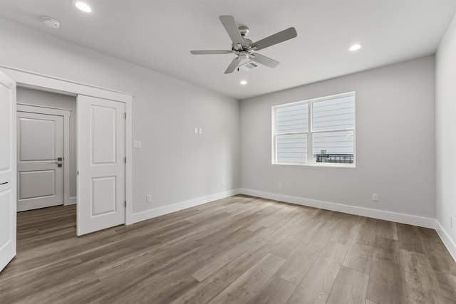 unfurnished room with ceiling fan and wood-type flooring