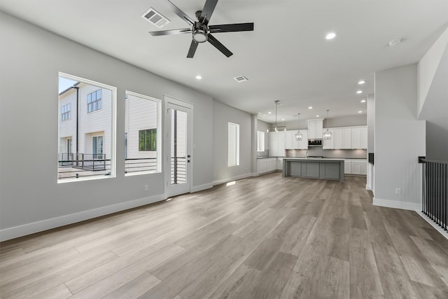 unfurnished living room with ceiling fan and light wood-type flooring