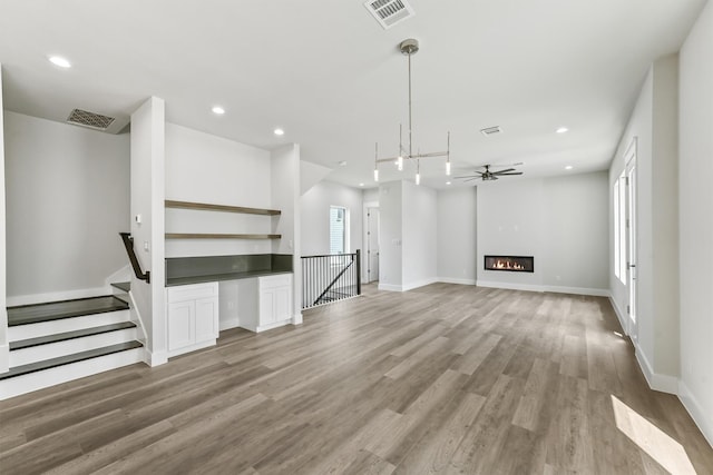 unfurnished living room with ceiling fan and light wood-type flooring