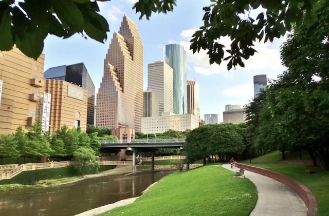 view of property's community with a lawn and a water view