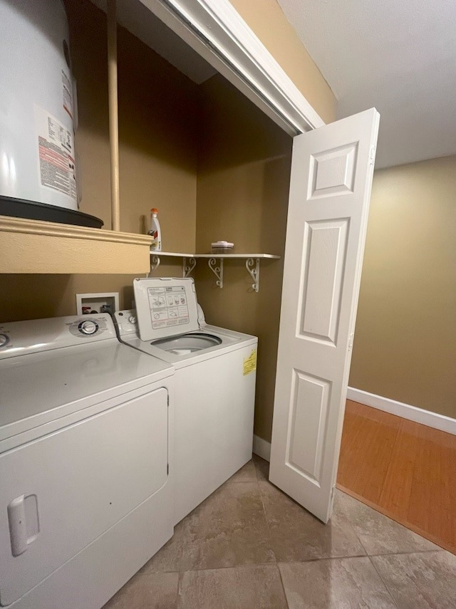 clothes washing area featuring washing machine and clothes dryer and light hardwood / wood-style flooring