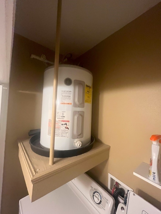 utility room featuring electric water heater and washer / dryer