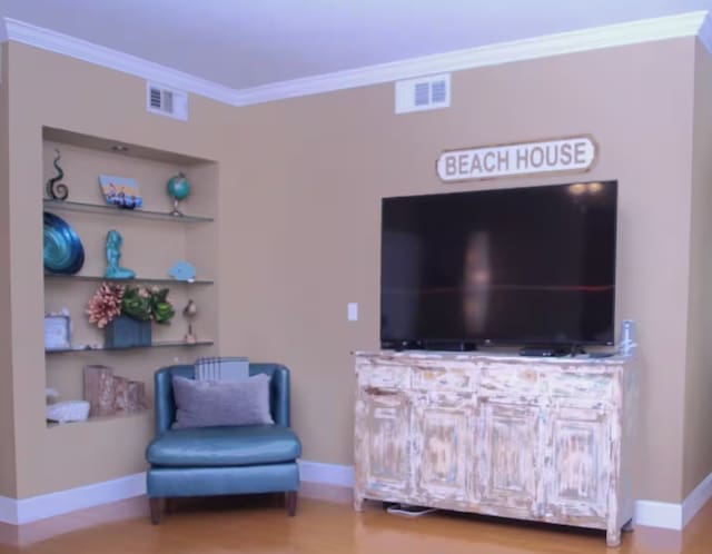 sitting room with hardwood / wood-style floors and crown molding