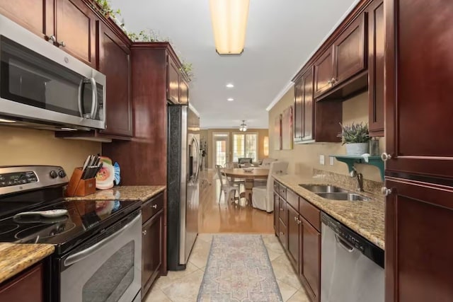 kitchen featuring light stone countertops, appliances with stainless steel finishes, and sink