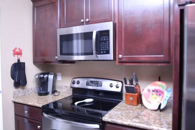 kitchen with appliances with stainless steel finishes and light stone counters