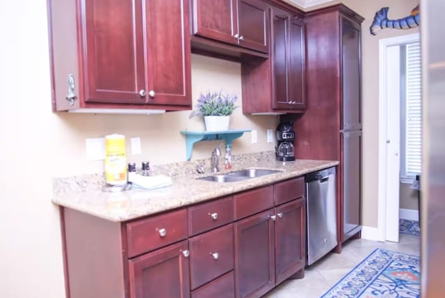 kitchen featuring light tile patterned floors, sink, light stone counters, and dishwasher