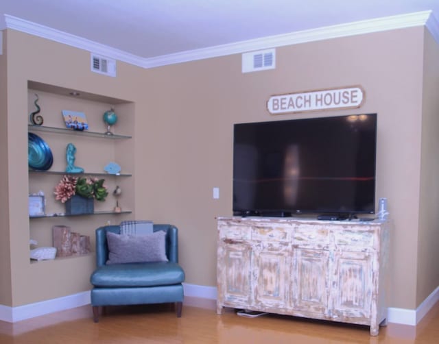 sitting room with wood-type flooring and crown molding