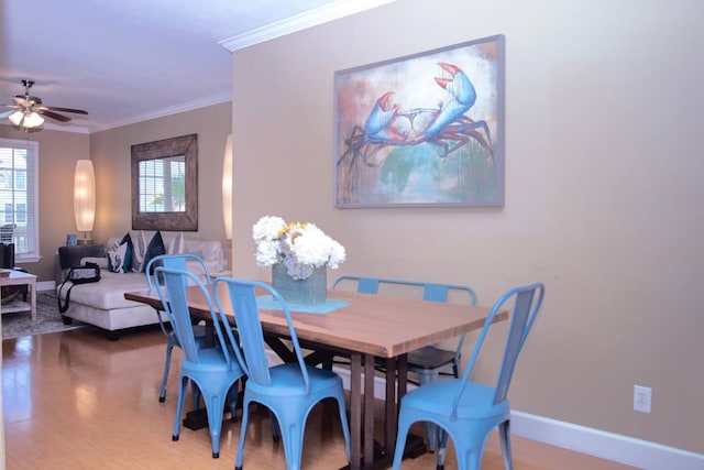 dining space featuring wood-type flooring, ceiling fan, and crown molding