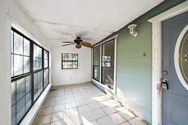 unfurnished sunroom featuring ceiling fan