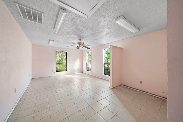 unfurnished room featuring light tile patterned flooring, ceiling fan, and a textured ceiling