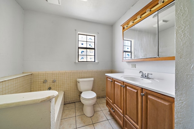 bathroom featuring tile walls, vanity, tile patterned flooring, toilet, and a washtub