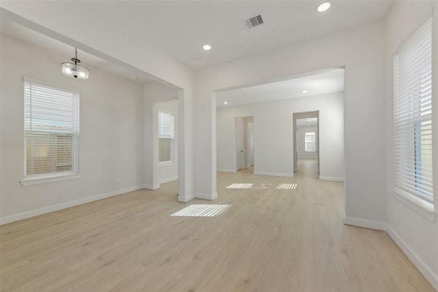 interior space featuring light wood-type flooring and a notable chandelier