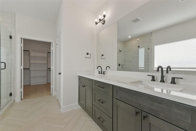 bathroom with a shower with door and vanity